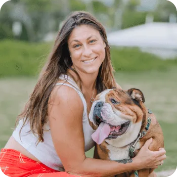 Rebecca C. smiling with her English bulldog, showcasing a bond of care and companionship, reflecting the compassionate veterinary services at Pilina Vet.